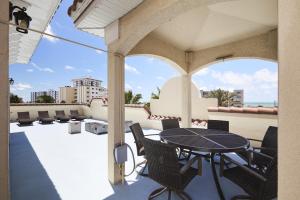 a patio with a table and chairs on a balcony at Mojito Haze beach retreat in St Pete Beach