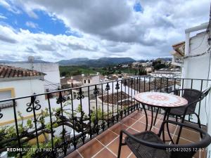 ein Balkon mit Tisch und Stühlen und Aussicht in der Unterkunft La Casita de la Parra in Ronda