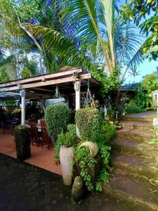 a patio with a table and chairs and trees at Whispering Hills in Perean