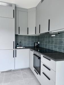 a kitchen with white cabinets and black counter tops at Newly built, bright apartment in Skien +21 photos