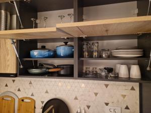 ein Küchenregal mit Töpfen, Pfannen und Geschirr in der Unterkunft Apartment ENJOY in Bar