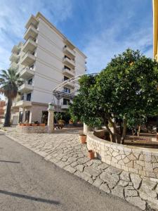 ein Gebäude mit Bäumen an der Straßenseite in der Unterkunft Apartment ENJOY in Bar