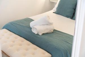 a bed with two towels sitting on top of it at Apartamentos Turísticos San José AT-BA-00359 in Almendralejo