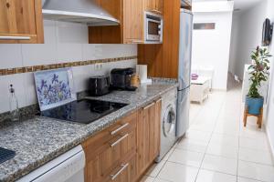 a kitchen with white appliances and wooden cabinets at Apartamentos Turísticos San José AT-BA-00359 in Almendralejo