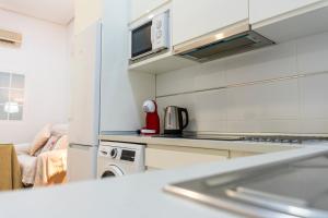 a kitchen with a stove and a microwave at Apartamentos Turísticos San José AT-BA-00359 in Almendralejo +5 photos