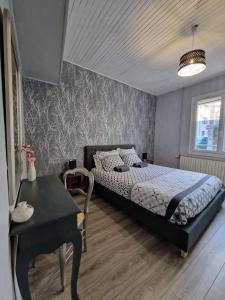 a bedroom with a bed and a table and a desk at Parenthèse Bergeracoise in Bergerac