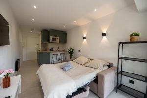 a bedroom with a large bed and a kitchen at Studio idéalement situé résidence front de mer in Saint-Laurent-du-Var