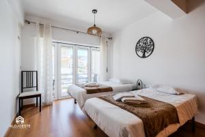 two beds in a room with a window at Estrela do Mar - Apartment center of Santa Cruz in Santa Cruz