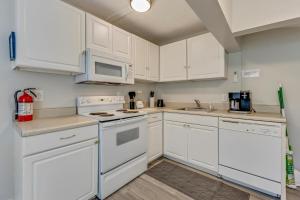 una cucina con armadietti bianchi ed elettrodomestici bianchi di Harper Haven by Carolina Beach Realty a Carolina Beach