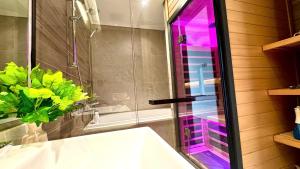 a bathroom with a tub and a glass shower at Onsen Ecopark Home in HÆ°ng YÃªn