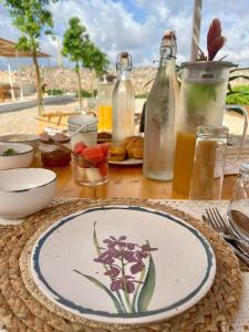 un tavolo con un piatto con un fiore dipinto sopra di Masseria Voluzzi a Copertino