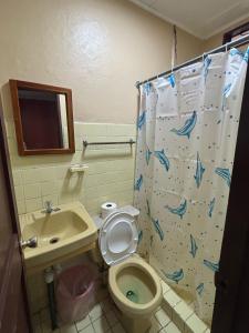 a bathroom with a toilet and a sink at Hotel Rio Mar in Puntarenas