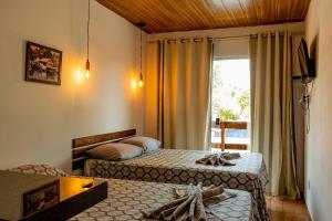 マラウにあるLofts da Vila BGのベッドが2つと窓があるホテルの部屋