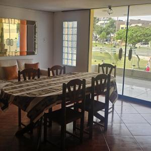 un tavolo da pranzo con sedie e una grande finestra di Hostal Turístico El Cajamarquez a Lima