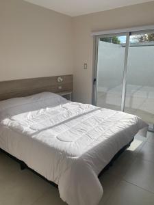 a white bed in a room with a window at Oxigeno2 in San Rafael