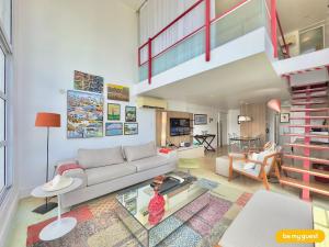 a living room with a couch and a staircase at Loft Praia - Meireles in Fortaleza