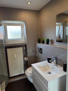 a bathroom with a sink and a toilet and a window at Ferienwohnung Klaus in Clausen +2 photos