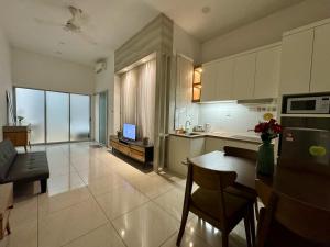 a kitchen and living room with a table and a couch at Manhattan Suites ITCC by KinabaluKomfortHomestay - Iverie in Penampang +12 photos