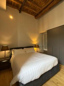 a bedroom with a large white bed with two lamps at Spiriti Home Apartment , New Opening Piazza di Pietra in Rome