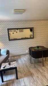 a living room with a table and a mirror at Green Hostel in Toruń +13 photos