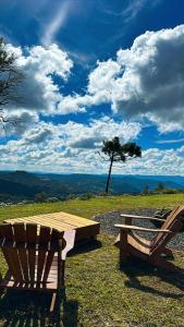 a picnic table and a bench on top of a field at Amanhecer - Essenziale in Urubici