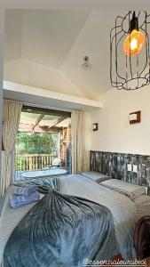 a bedroom with two beds and a chandelier at Amanhecer - Essenziale in Urubici