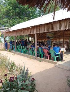 a group of people sitting in chairs under a pavilion at Redário Pô do Sol in Água Boa +10 photos