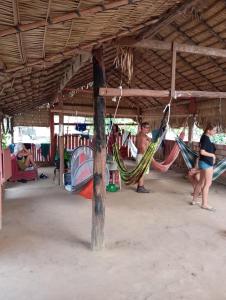 a group of people standing under a tent with hammocks at Redário Pô do Sol in Água Boa