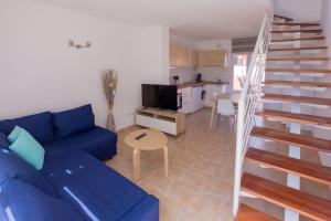 a living room with a blue couch and a kitchen at Alíseos in Costa de Antigua