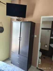 ein Badezimmer mit einem Schrank in der Ecke eines Zimmers in der Unterkunft Hotel Ifigenia Paralia Katerinis plaz in Paralia Katerinis