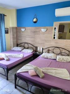 2 Betten in einem Zimmer mit lila Bettwäsche in der Unterkunft Hotel Ifigenia Paralia Katerinis plaz in Paralia Katerinis