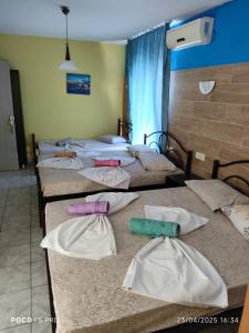 eine Gruppe von 4 Betten in einem Zimmer in der Unterkunft Hotel Ifigenia Paralia Katerinis plaz in Paralia Katerinis