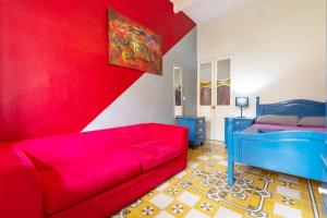a living room with a red couch and a bed at Double, twin or triple room with private bathroom, not ensuite! In quiet and budget friendly townhouse in Sliema