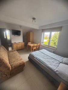 a bedroom with a bed and a table and chairs at Zuzanna in Trzęsacz