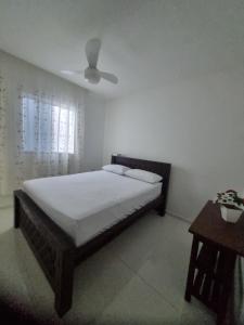 a bedroom with a bed and a ceiling fan at Casa na praia de Tamandaré in Tamandaré