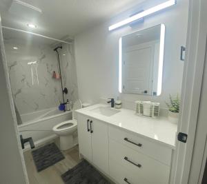 a bathroom with a sink and a toilet and a mirror at Carrington Cozy Suite, Calgary in YYC