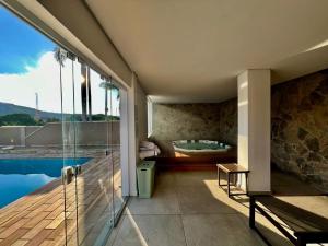 a house with a swimming pool and a bath tub at Villa do Éden in Lindóia