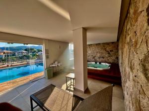 a living room with a pool and a stone wall at Villa do Éden in Lindóia