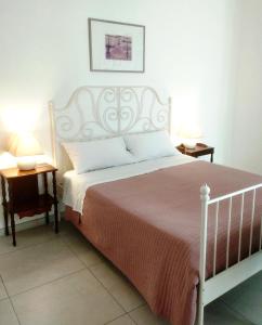 een slaapkamer met een wit bed en 2 lampen op tafels bij Casa Vacanza -Trani centro in Trani