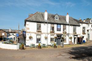 ein weißes Gebäude am Straßenrand in der Unterkunft Waterfront Cottage - Apple Pie Luxury Escapes in Calstock