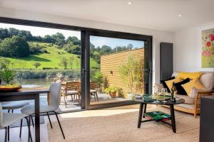 ein Wohnzimmer mit Tisch und ein Esszimmer in der Unterkunft Waterfront Cottage - Apple Pie Luxury Escapes in Calstock