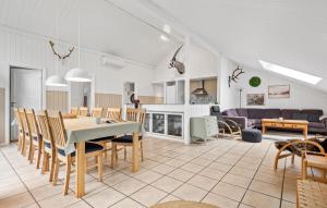 a dining room and living room with a table and chairs at 5 Bedroom Lovely Home In Oksbøl in Oksbøl