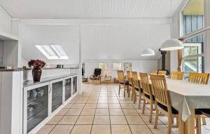 a kitchen and dining room with a table and chairs at 5 Bedroom Lovely Home In Oksbøl in Oksbøl