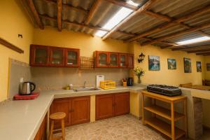 a large kitchen with wooden cabinets and a sink at Yuyay Wasi Bungalows in Urubamba +26 photos