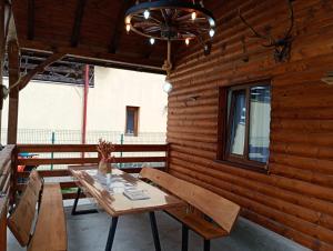 a wooden room with a wooden table and a chandelier at Casuta Adelina Borsa in Borşa