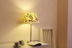 a lamp on a table with a book and coffee cups at Casa Vista Serapo in Gaeta