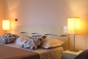 a bedroom with a bed with pillows and two lamps at Casa Vista Serapo in Gaeta