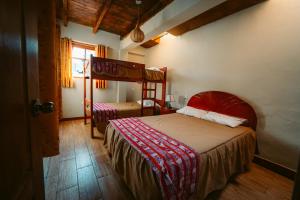a bedroom with two bunk beds and a window at Yuyay Wasi Bungalows in Urubamba