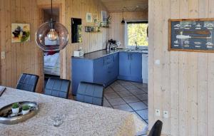 a kitchen with blue cabinets and a table with chairs at 3 Bedroom Amazing Home In Hemmet in Hemmet