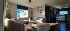 a living room with a table and chairs and a kitchen at Home in Sylta